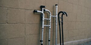 Thumbnail image of crutches against a wall with a question mark above, representing FAQs about crutch rental.