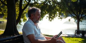 Paciente com andador em parque ensolarado